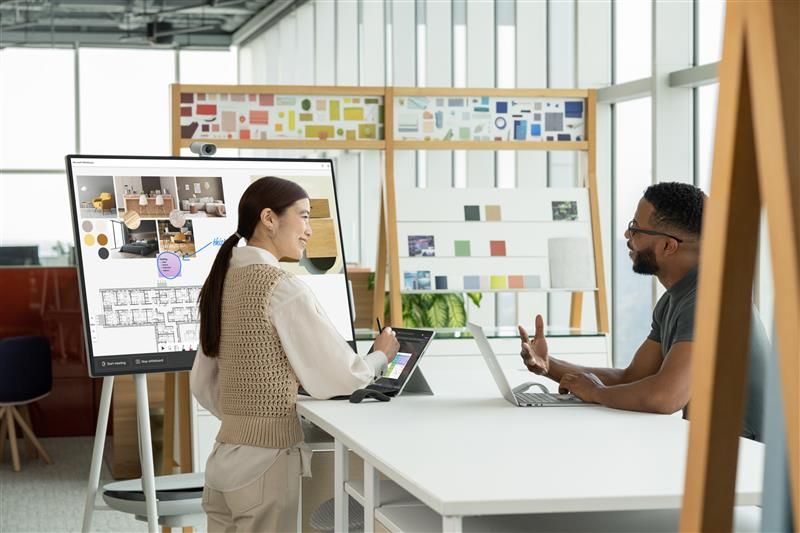 Dos personas observan un dispositivo Surface Hub