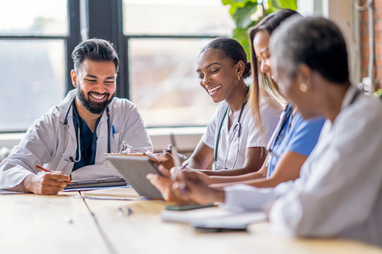 Personal médico en una sala de juntas observa una tablet