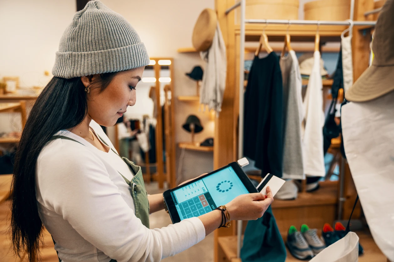 Una mujer utiliza una tablet dentro de una tienda de ropa