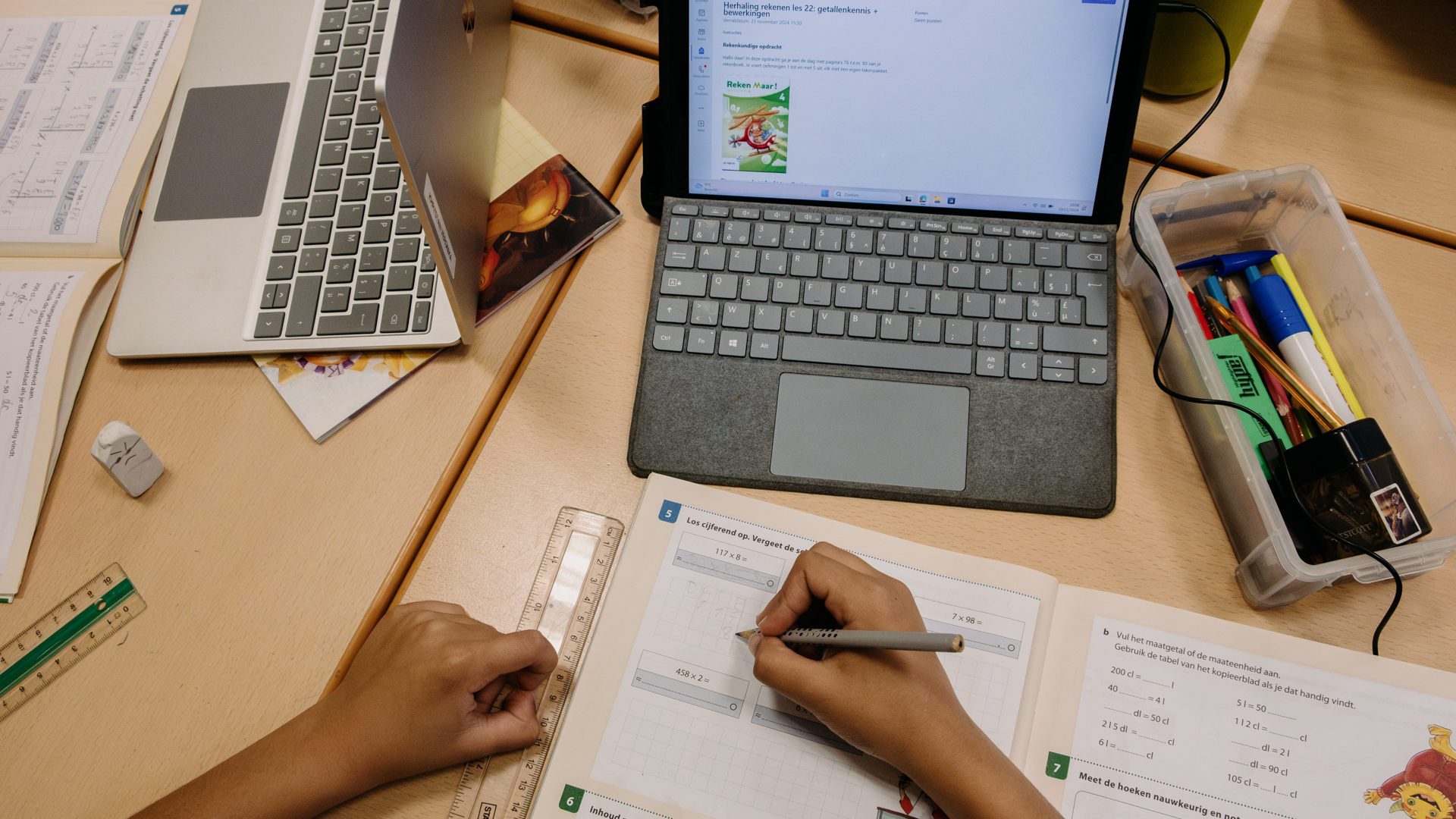 Acercamiento al cuaderno y Microsoft Surface de un niño en el aula