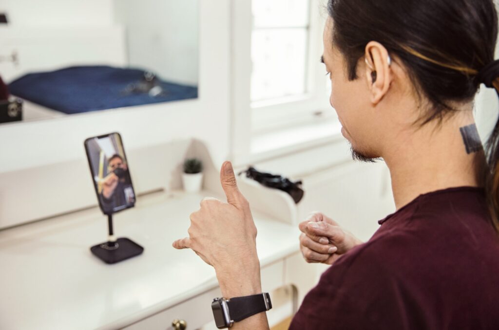 Un hombre utiliza lenguaje de señas en una videollamda desde un teléfono
