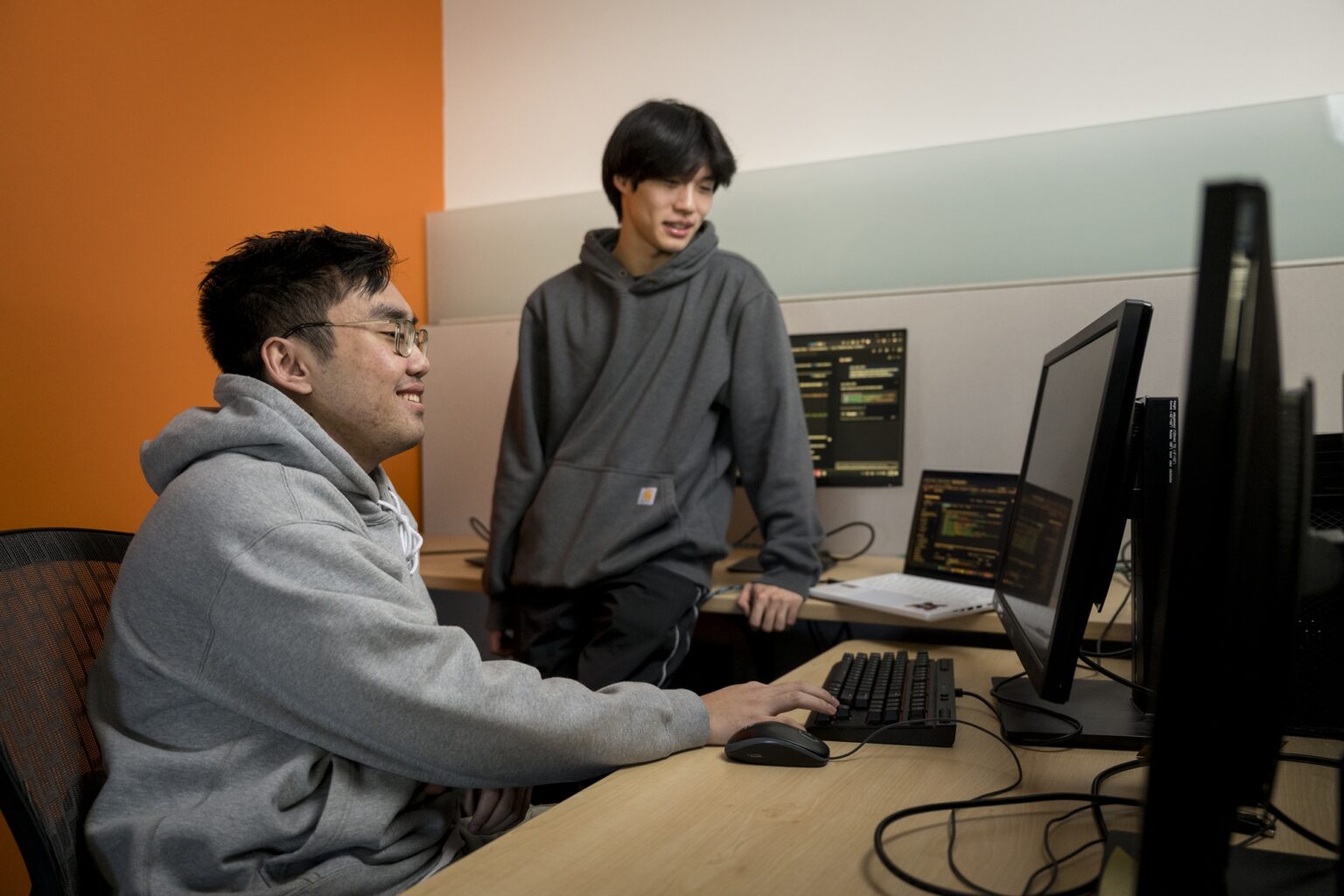 Dos estudiantes universitarios trabajan en una computadora