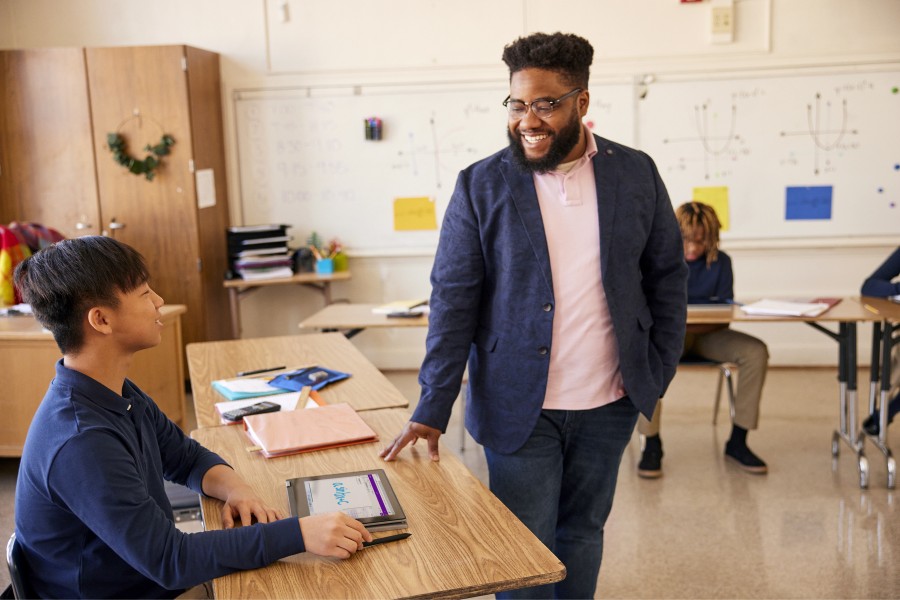 Un educador interactuando con un estudiante en un entorno de aula.